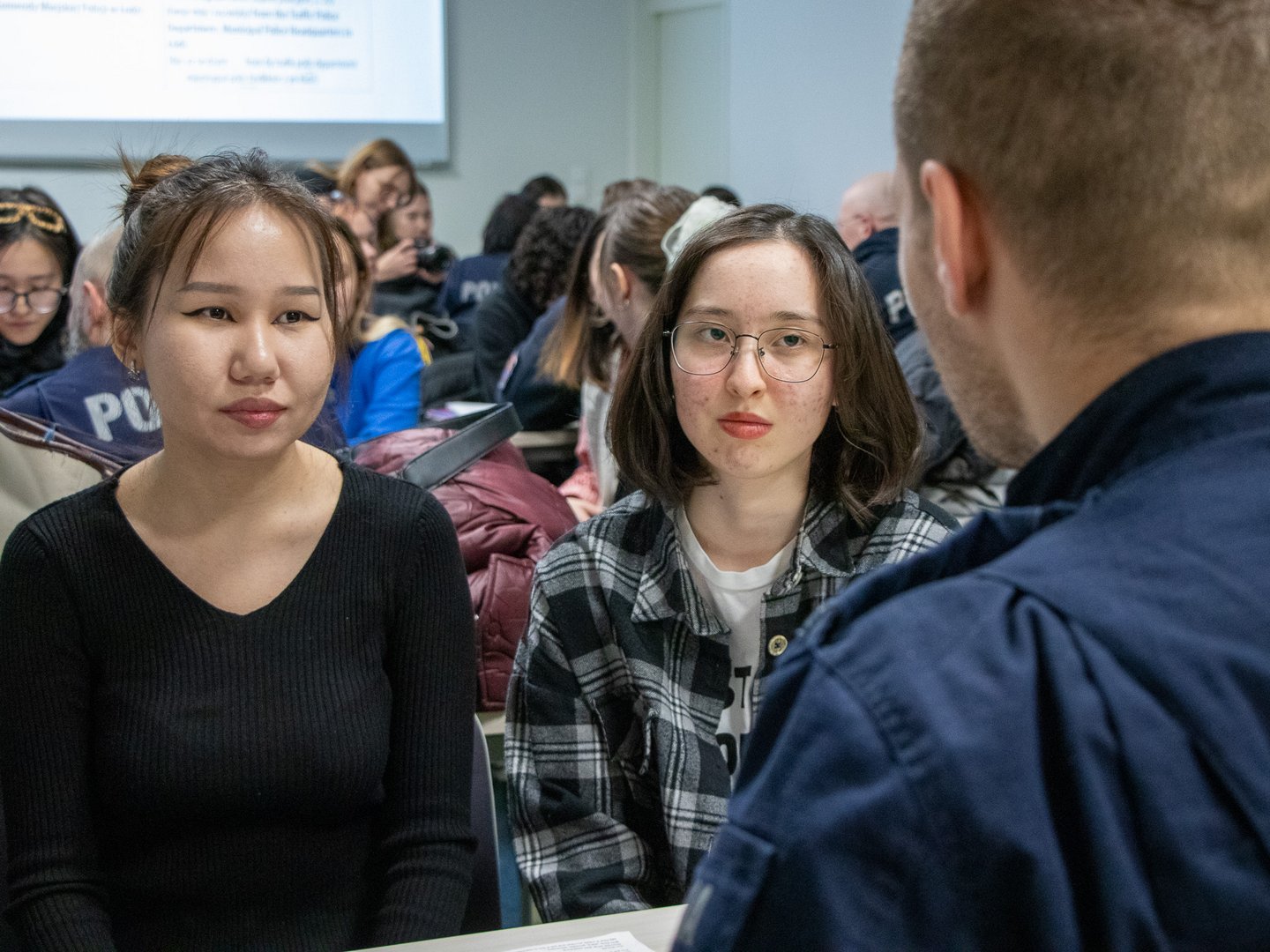 policjant w trakcie rozmowy ze studentkami