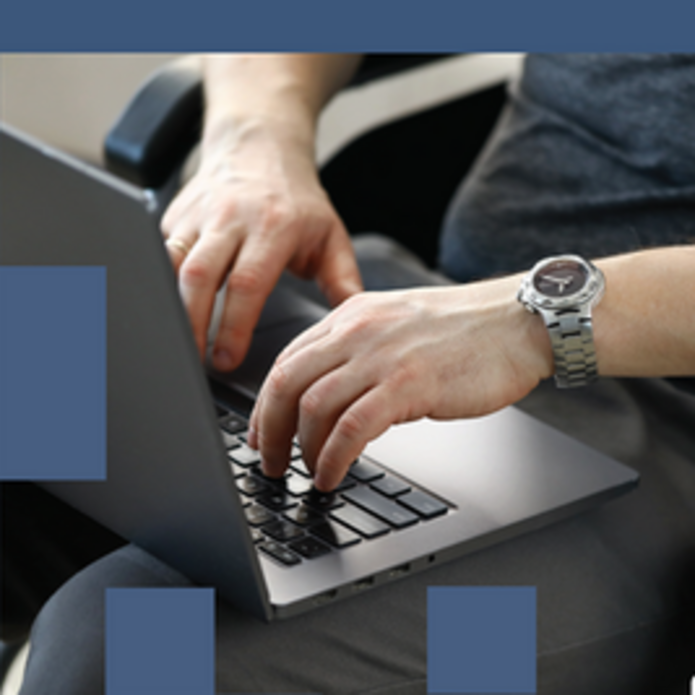 osoba na wózku inwalidzkim pracująca na laptopie