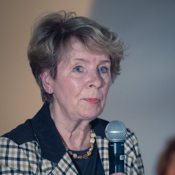 an elderly woman holding a microphone