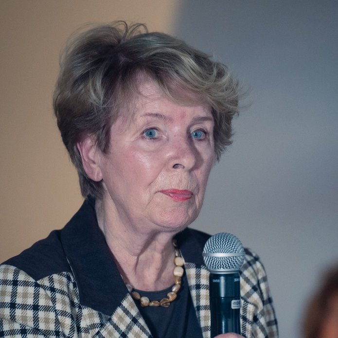 starsza kobieta trzymająca mikrofon