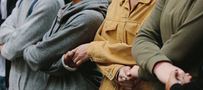 Stojące obok siebie osoby trzymające się za ręce