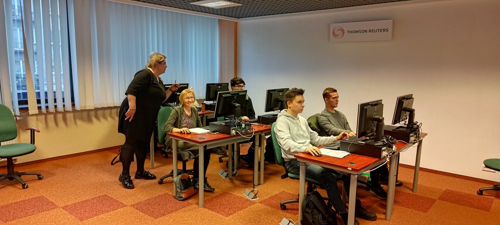 Jedna z prowadzących szkolenie podchodzi do uczestników pracujących przy komputerach, aby im pomóc, podpowiedzieć jak wykonać zadane cwiczenia