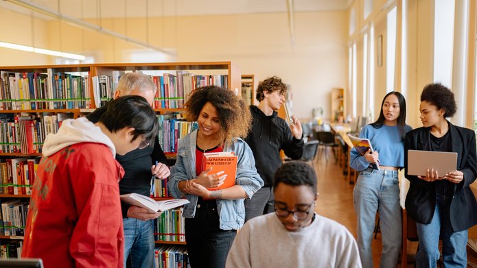młodzi ludzie rozmawiają w przestrzeni bibliotecznej