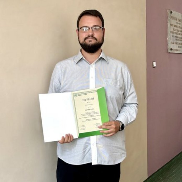 Osoba trzymająca w ręce dyplom