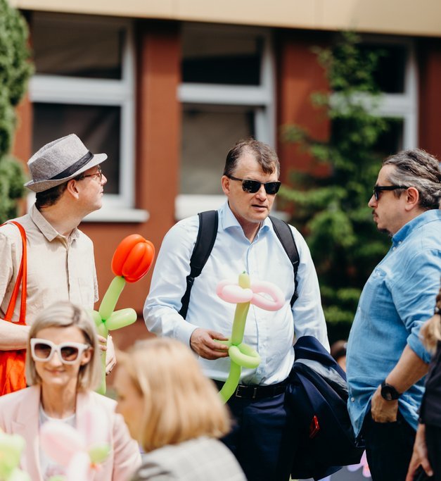 grupa ludzi trzymająca kwiaty z balonów na zewnątrz