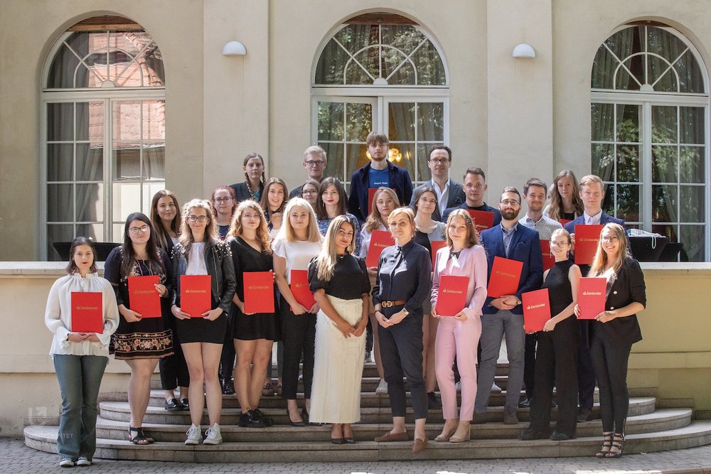 Nagrodzeni studenci pozujący do zdjęcia z dyplomami