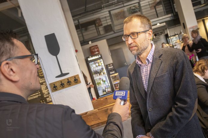 prof. Piotr Krajewski podczas śniadania prasowego UŁ rozmawia z dziennikarzem TV