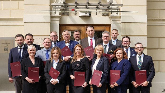 Grupa ludzi trzymająca podpisane porozumienia