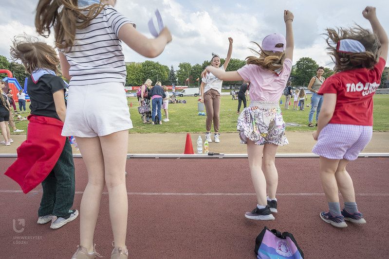 Dzieci skaczące na bieżni boiska